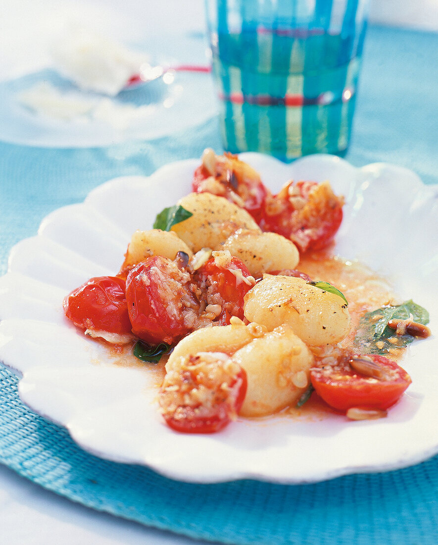 Gnocchi with roasted tomatoes and pine nuts on plate