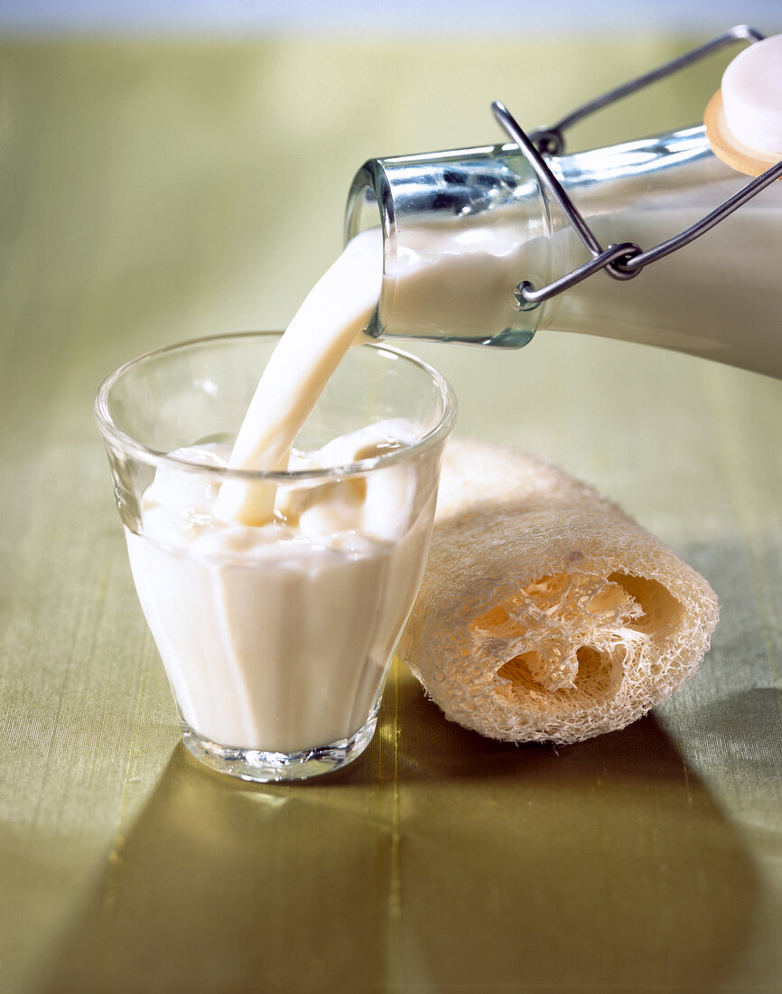 Close-up of Goat's milk being poured in a small glass