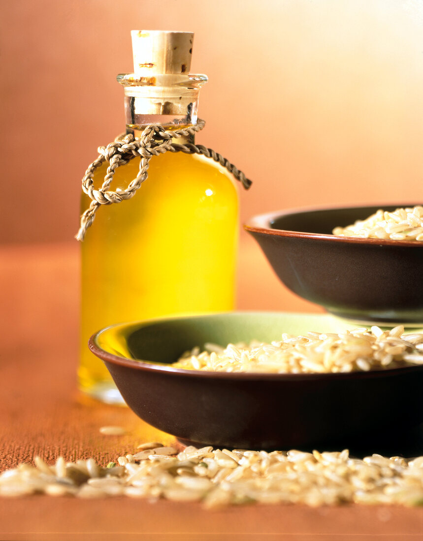 Reisoel oil in bottle and rice seeds in bowl