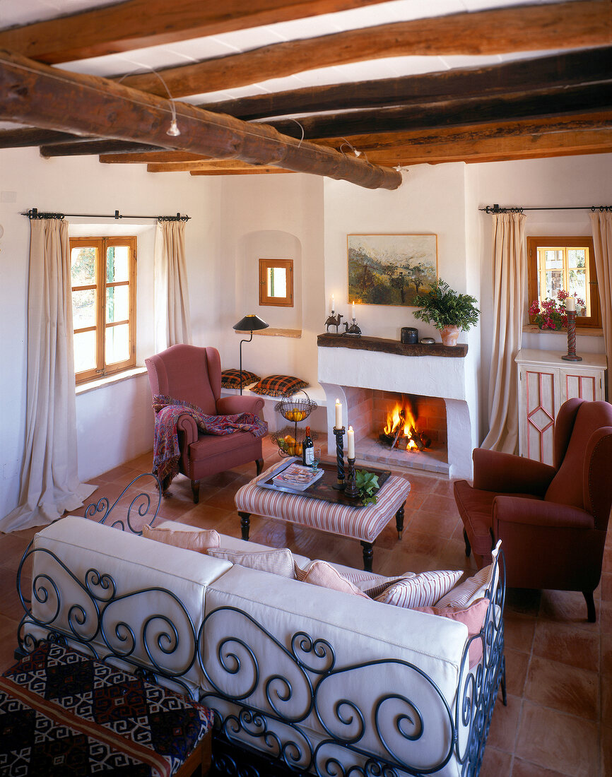 Living room with beamed ceiling, rustic furniture and fireplace