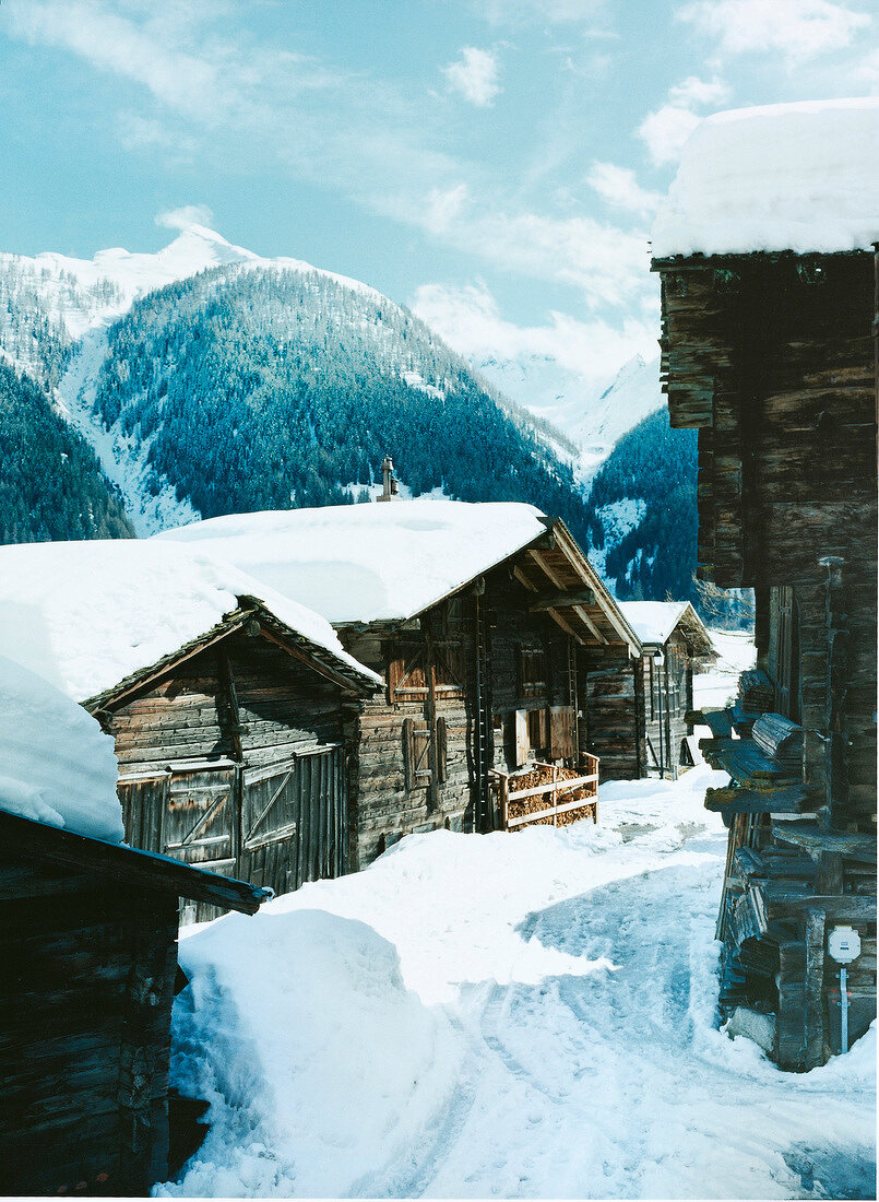 View of snow-capped mountains and wooden cabins