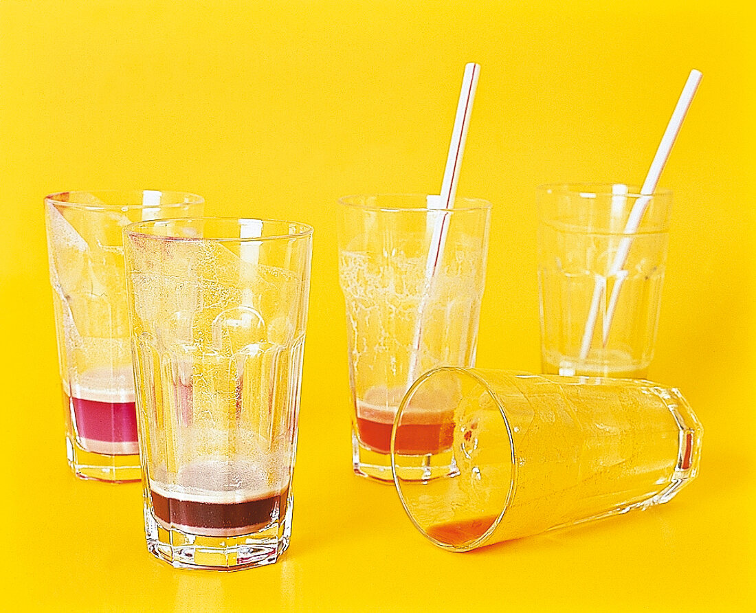 Rest von Diät-Drinks in Gläsern, Strohhalme, Hintergrund gelb