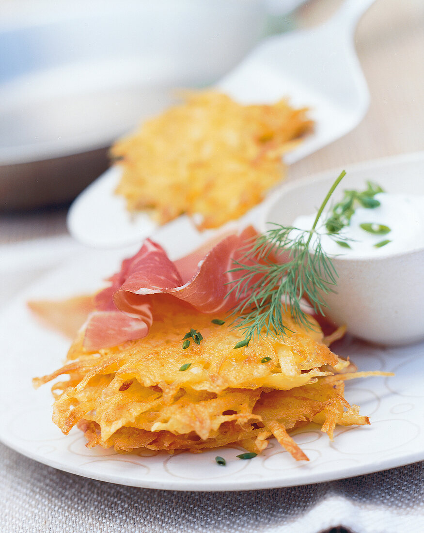 Potato rosti and ham with herb cream on plate