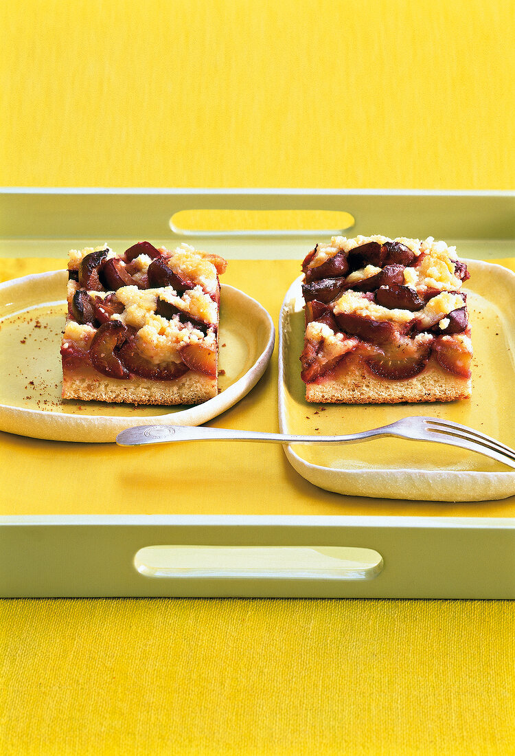Plum cake with almond on yellow plate