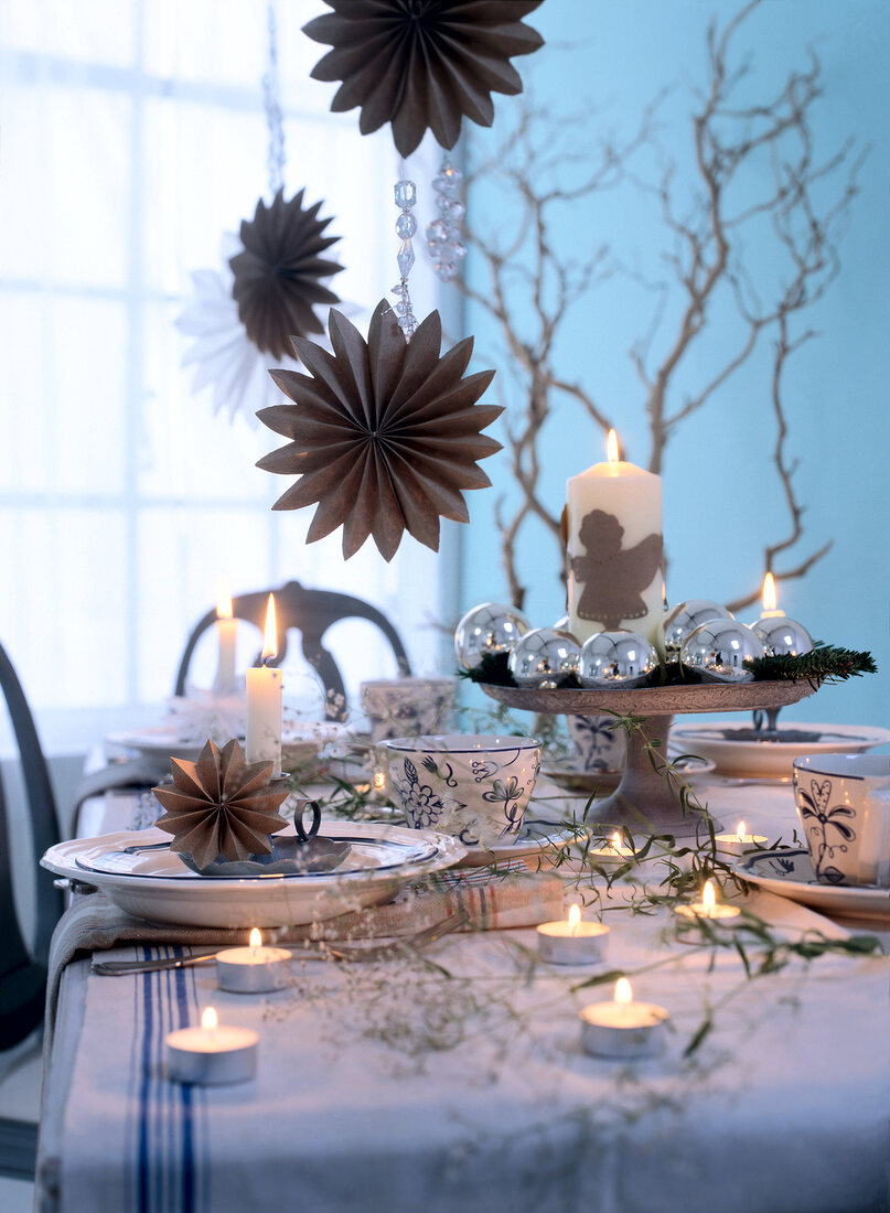 Christmas decorations with tea lights and candles on dining table