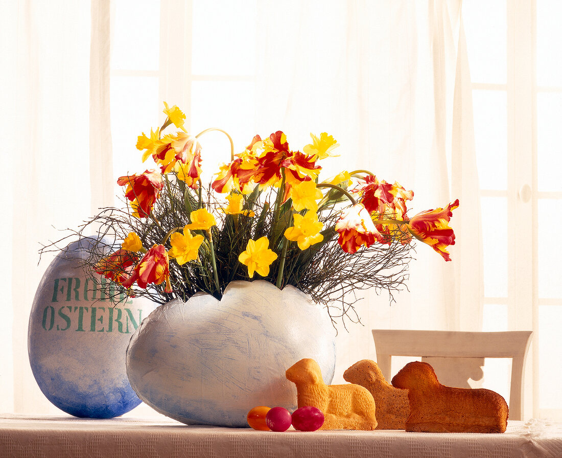 Bouquet of spring flowers in Easter eggs on table