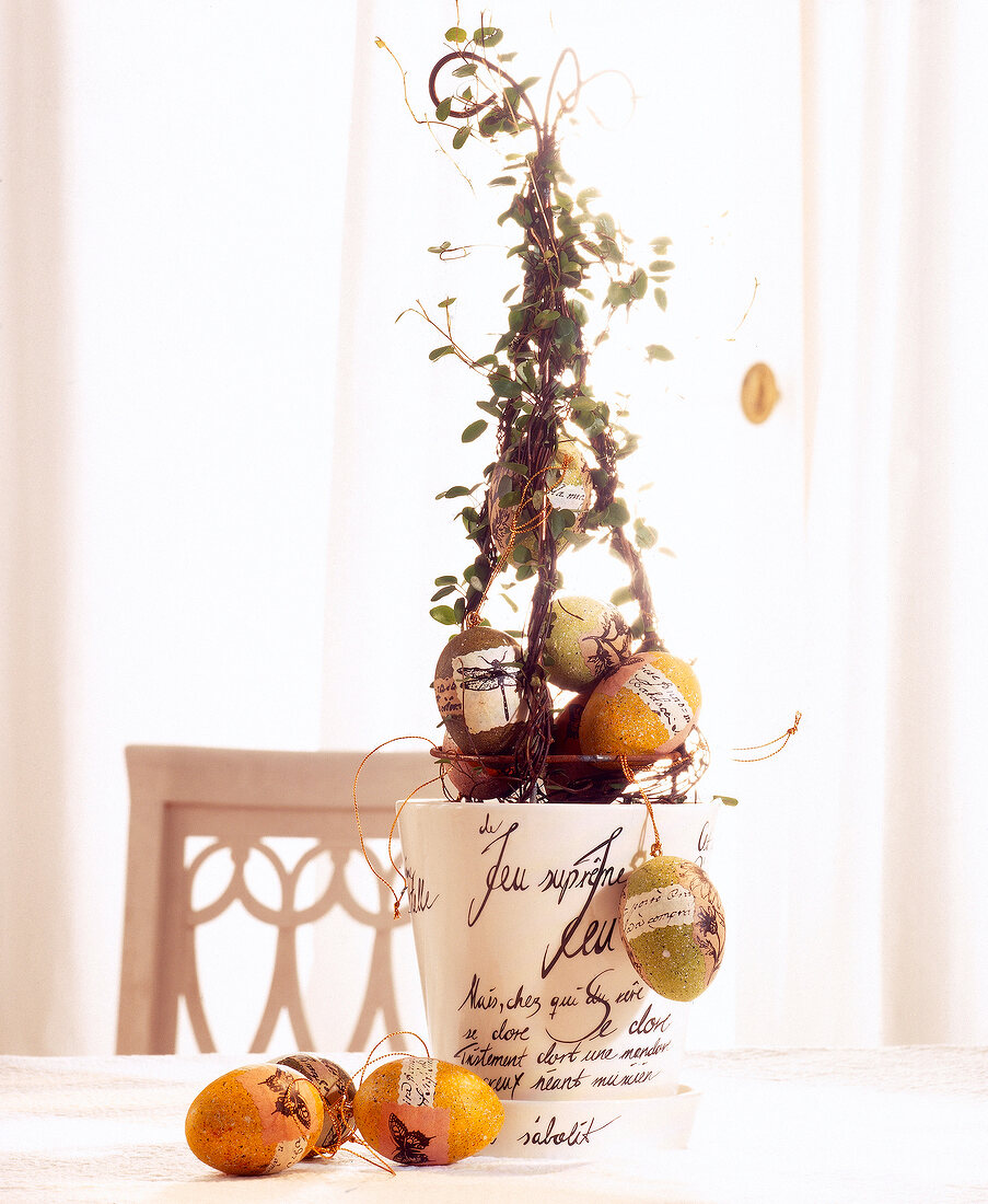 Pyramid of wire wrapped with vines, planter and eggs made of paper mache