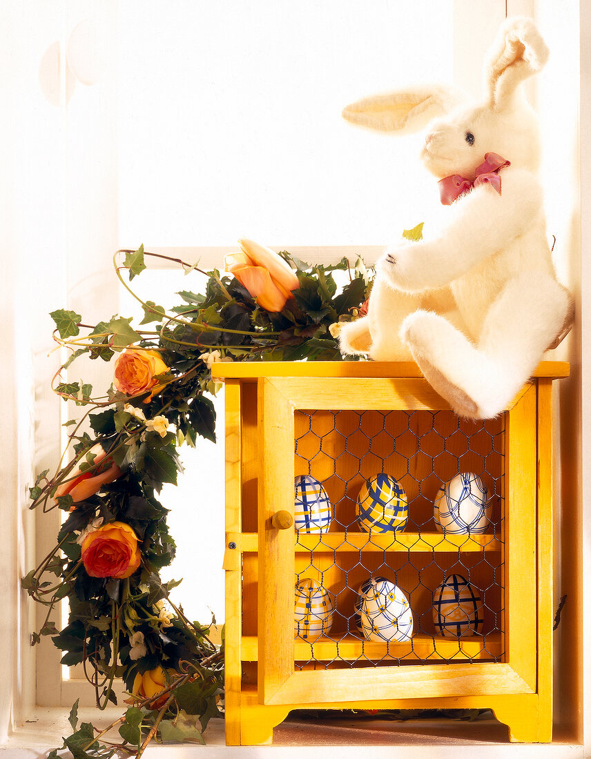 Wreath, bunny and yellow Easter eggs in closet