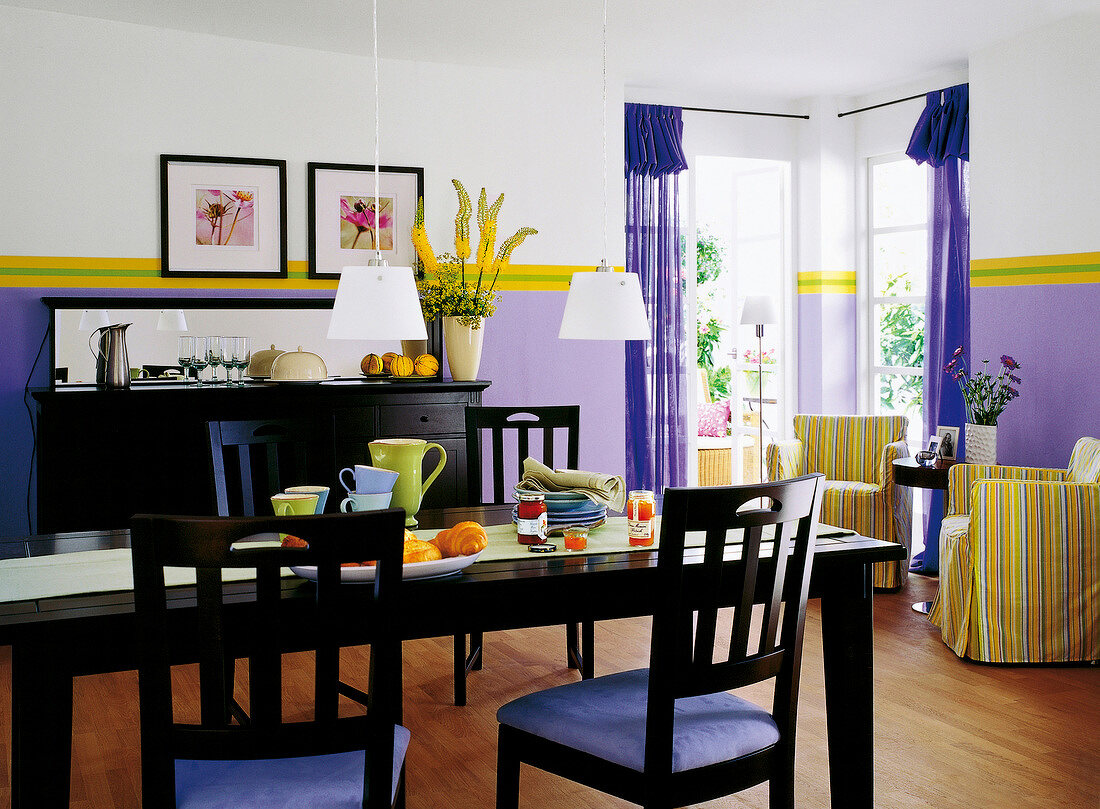 Esszimmer in Violett und Schwarz: dunkle Holzmöbel, Blick auf Terrasse