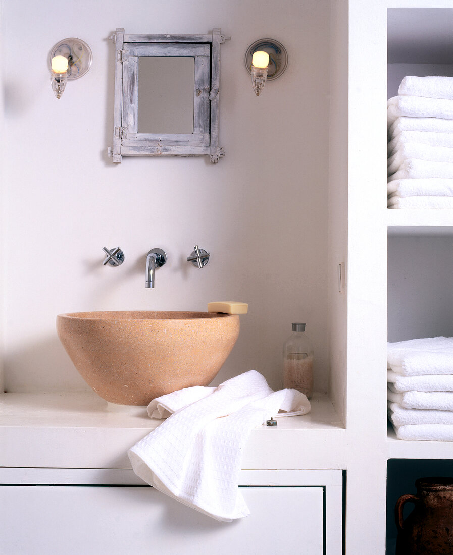 Sink and shelf with white towels in bathroom