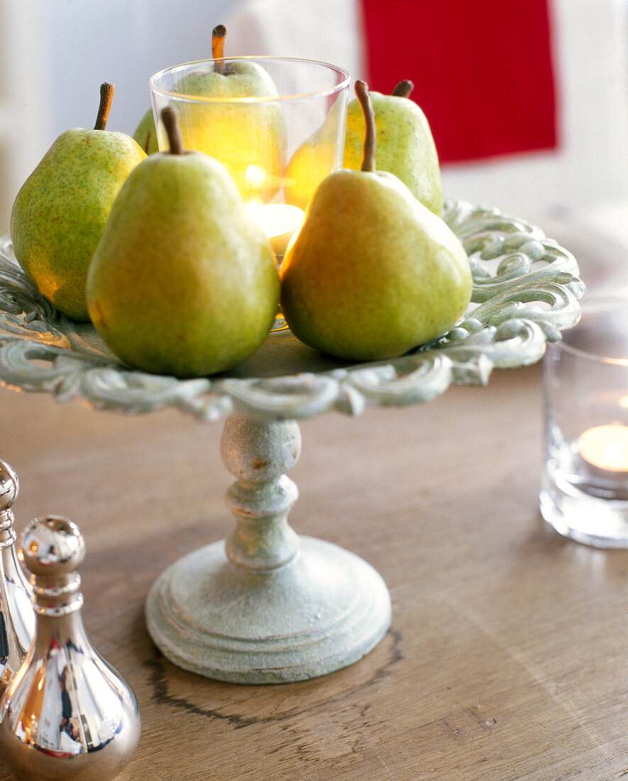 Pears around lit candles on iron stand