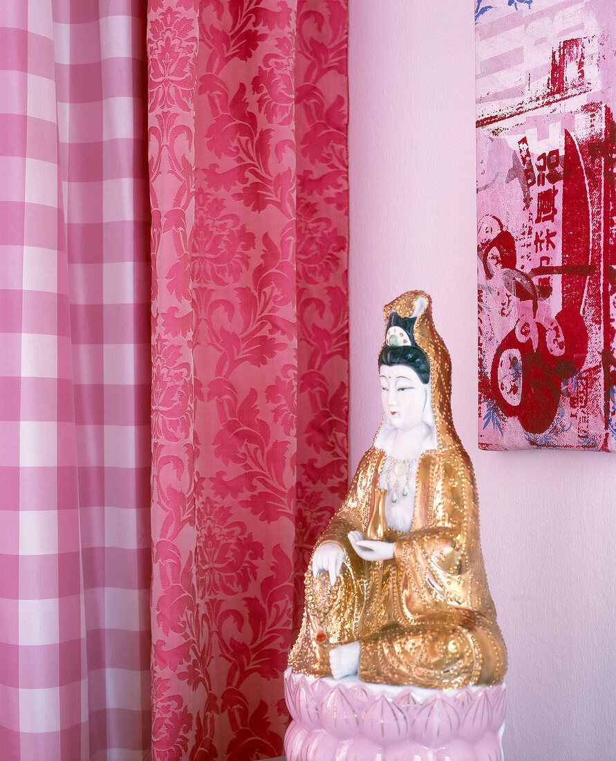 Golden Chinese statue beside red curtains