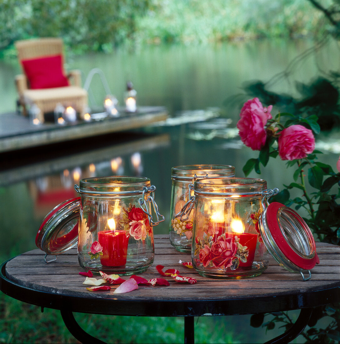 Glass lanterns on wooden table in garden