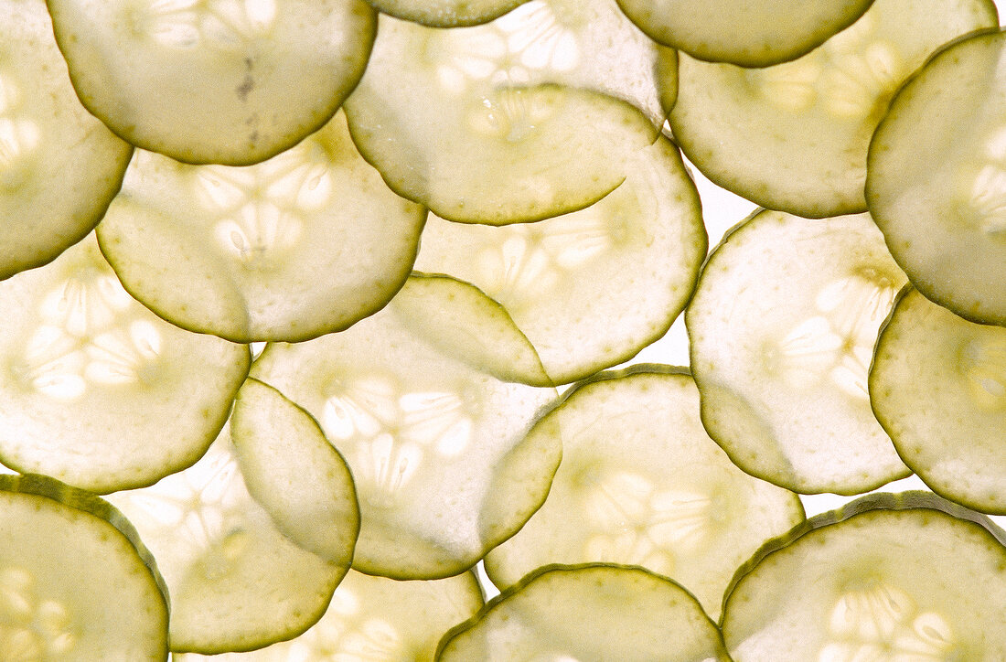 Thin slices of cucumber on white background