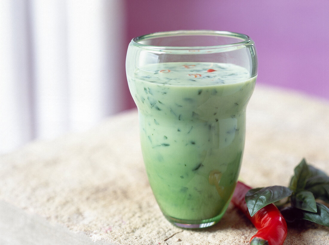 Glass of spicy green lassi with basil