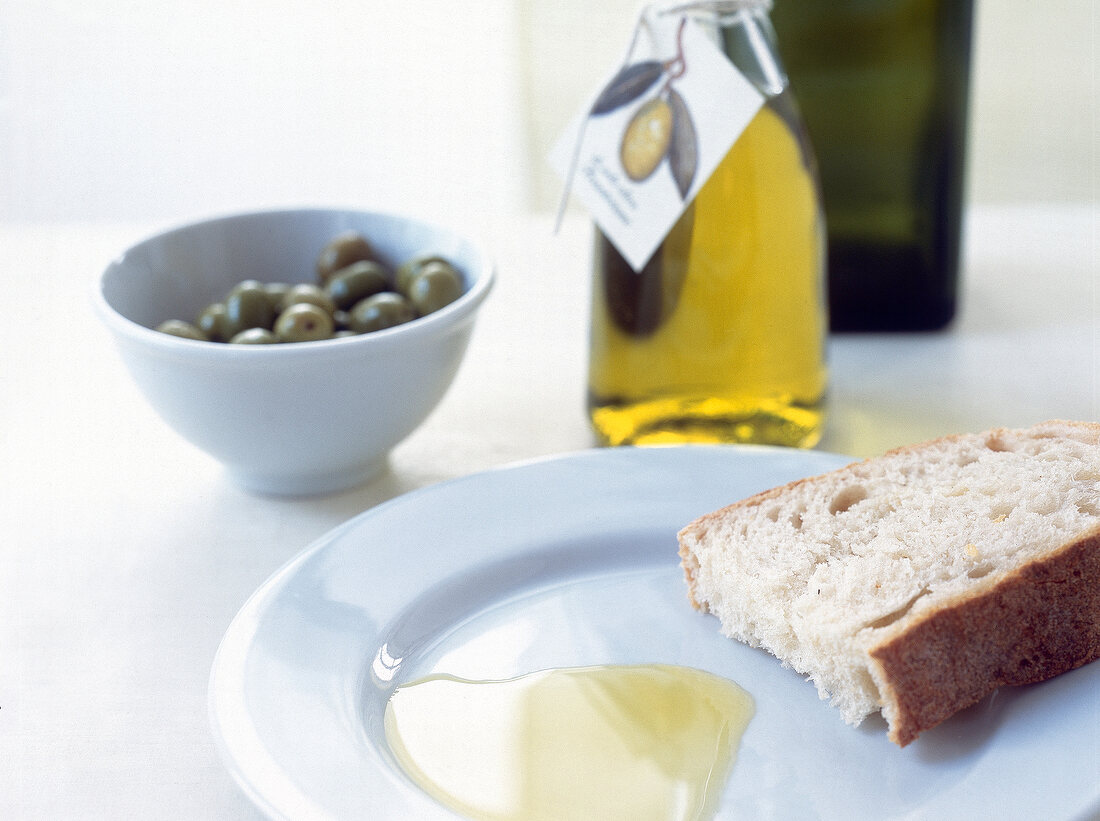 Olive oil and piece of bread on plate