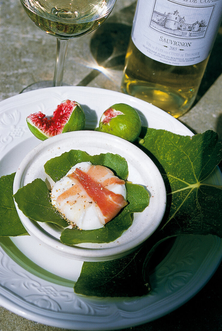 Baked goat cheese with ham on plate