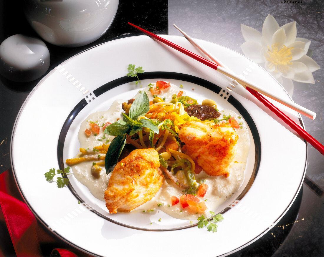 Monkfish, noodles and curry on dish chop with sticks, Euro-Asian cuisine