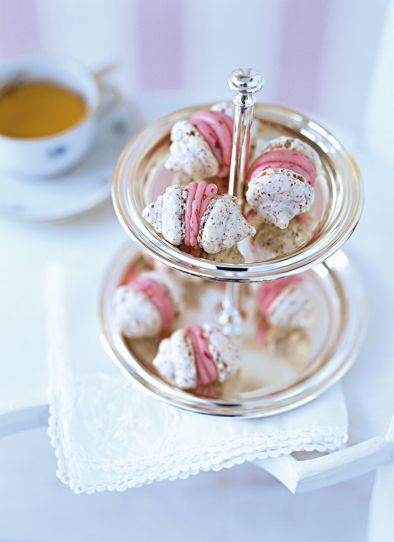 Close-up of mini macaroons with raspberry cream on tiered stand