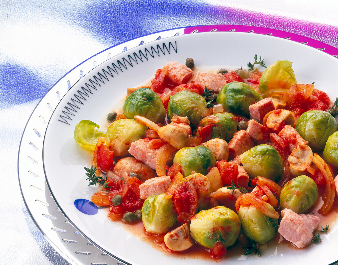 Microwave cooked brussels sprouts with smoked pork, tomatoes and mushrooms on dish