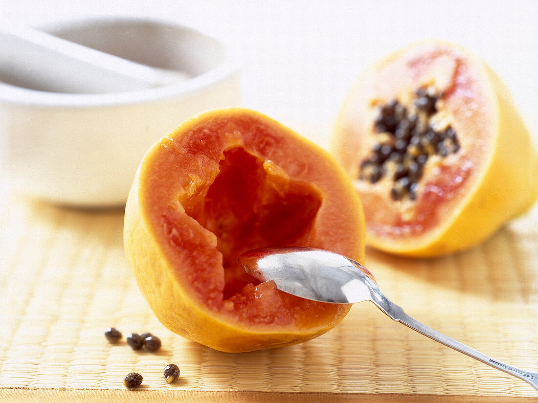 Close-up of halved papaya with spoon