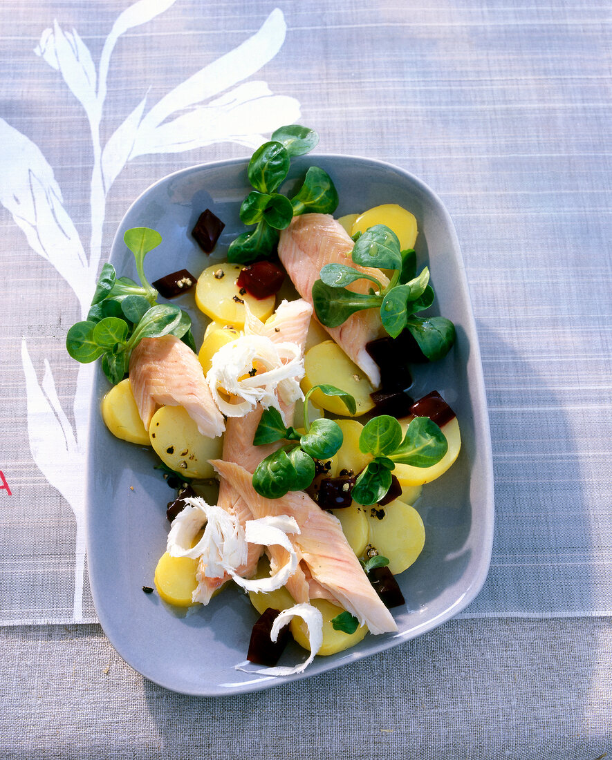 Beetroot salad with trout fillet on purple fancy dish