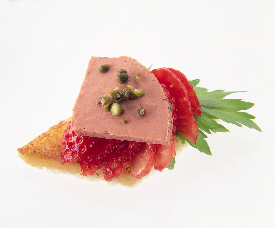 Close-up of foie grass and strawberries with toast on white background