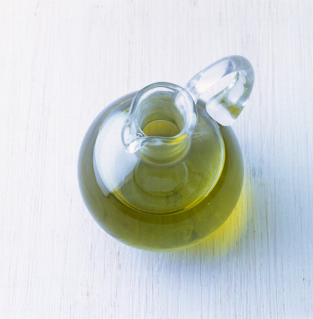 Close-up of cold pressed olive oil in a bird's-eye glass carafe