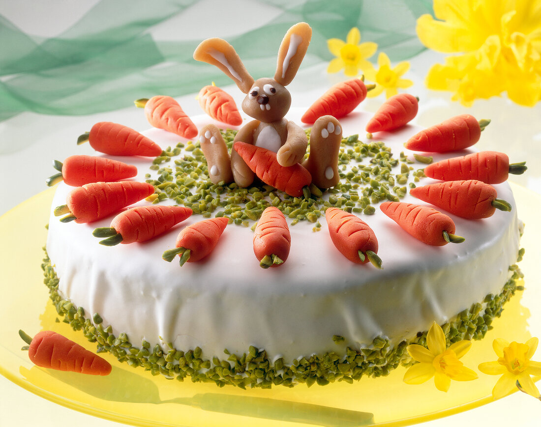 Easter cake with carrots, orange cream and Easter bunny on top of cake