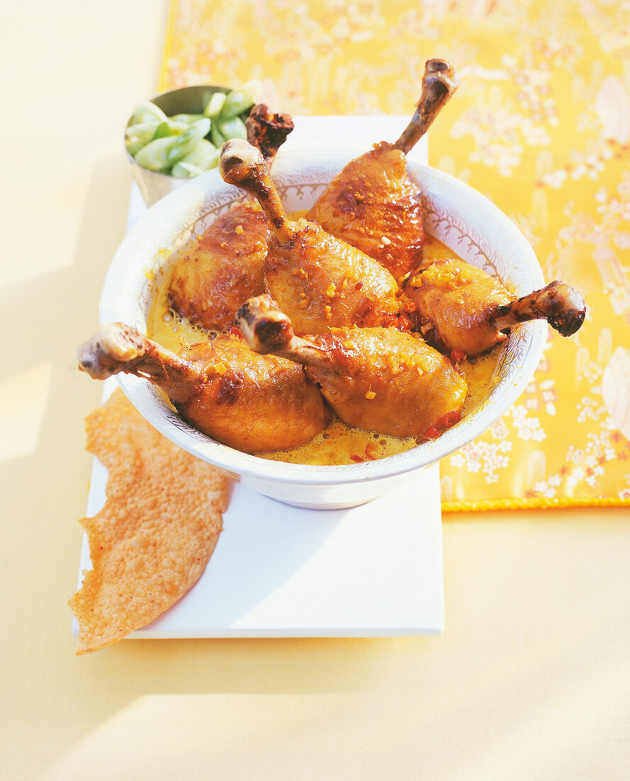 Chicken drumsticks with yoghurt sauce in bowl