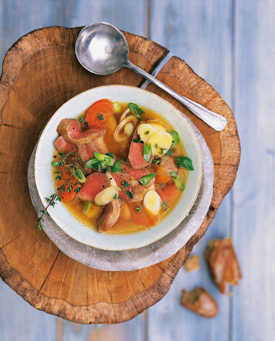 Lamb stew in bowl on tree stump