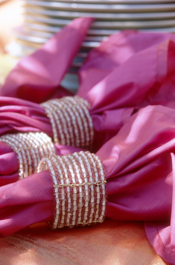 Pinkfarbene Servietten, Servietten- ringe aus Perlenbändern