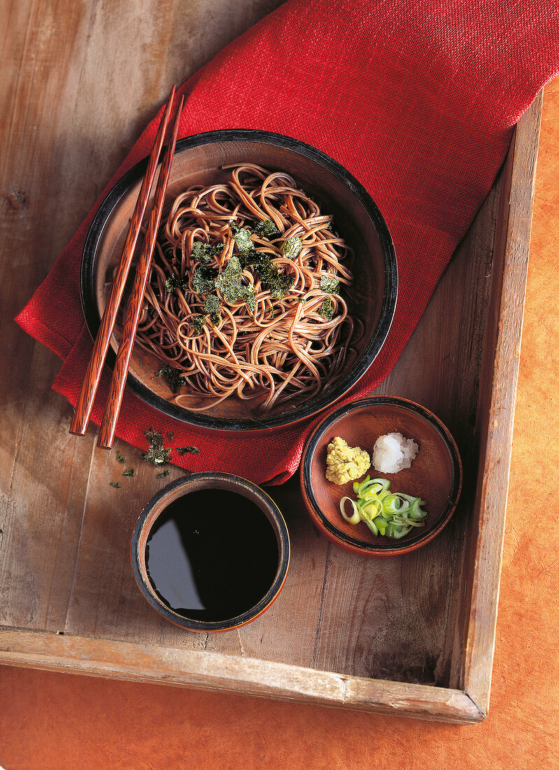 Soba noodles with tamari sauce in wooden bowl