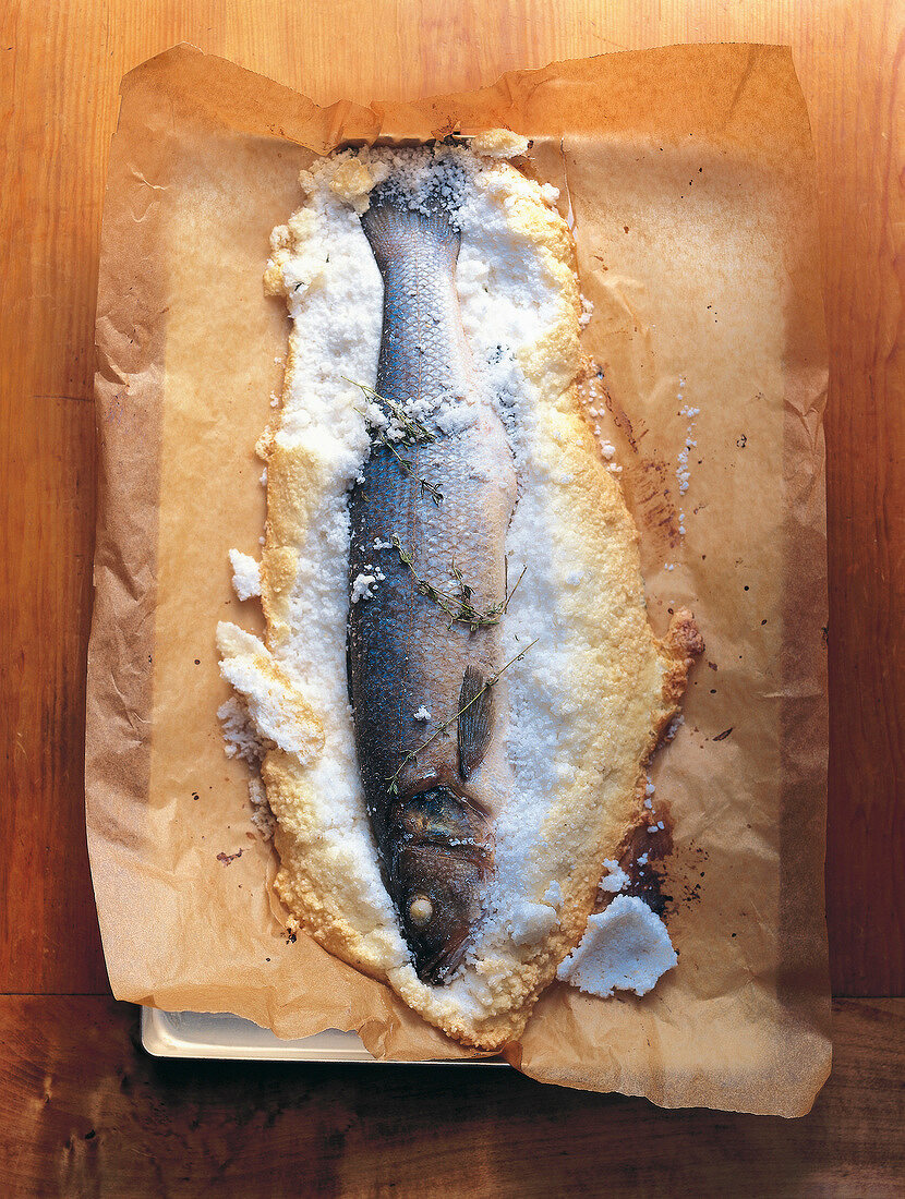 Sea bass in salt crust on baking paper
