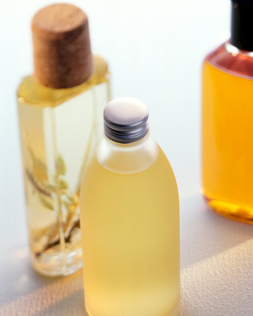 Close-up of several bottles of bath oil on white background