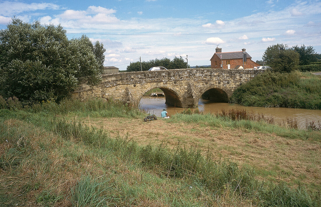 Landschaft mit kleinem Fluß und Steinbrücke