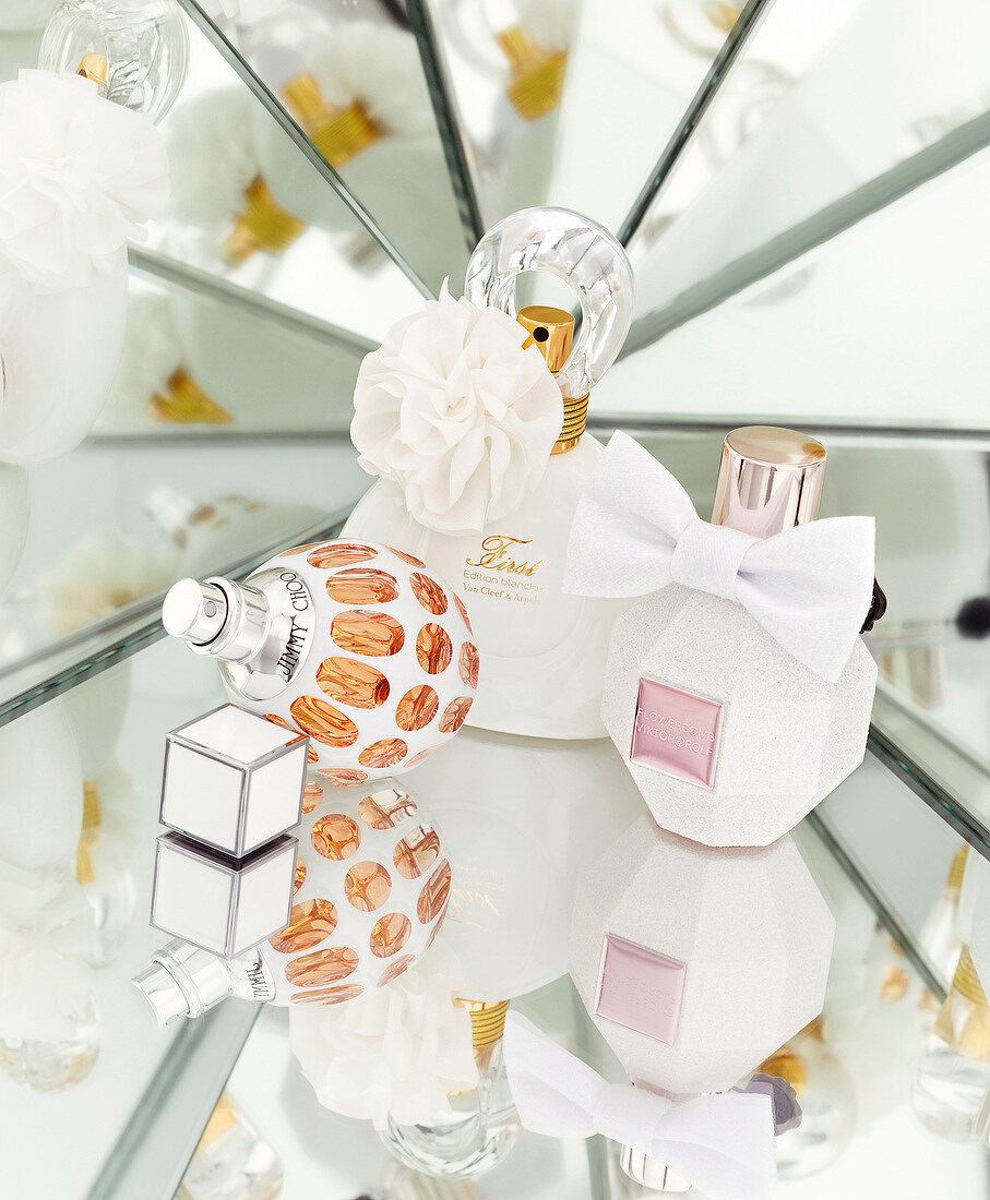 Three perfume bottles with white bows on glass