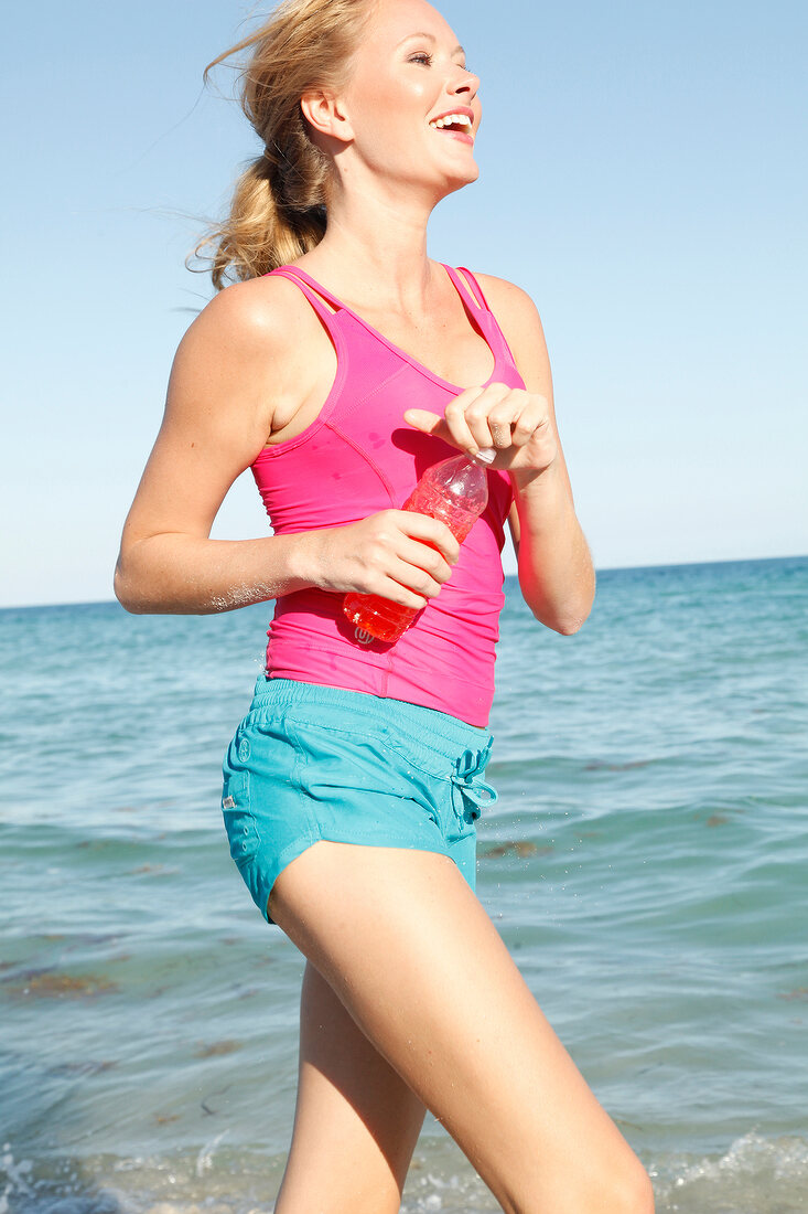 Blonde, sporty woman with a ponytail on the beach