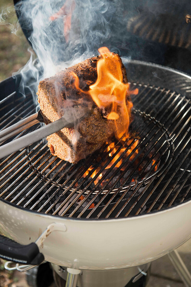 Rib-Eye-Steak auf dem Grill, Grillzange