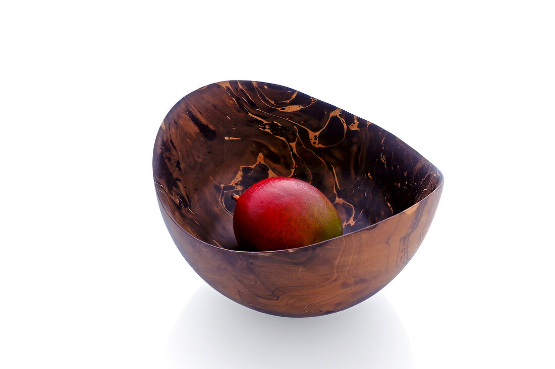 A fruit in a decorative wooden bowl