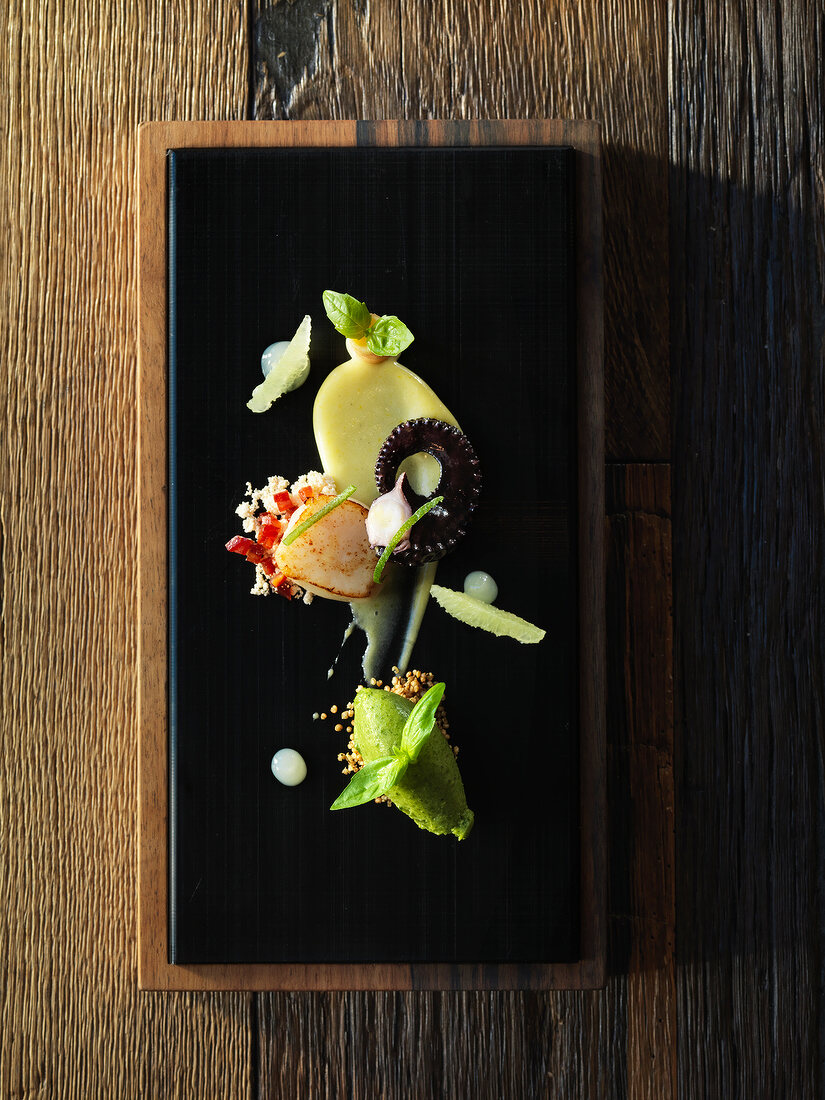 A composition of appetisers featuring scallops, squid and basil sorbet