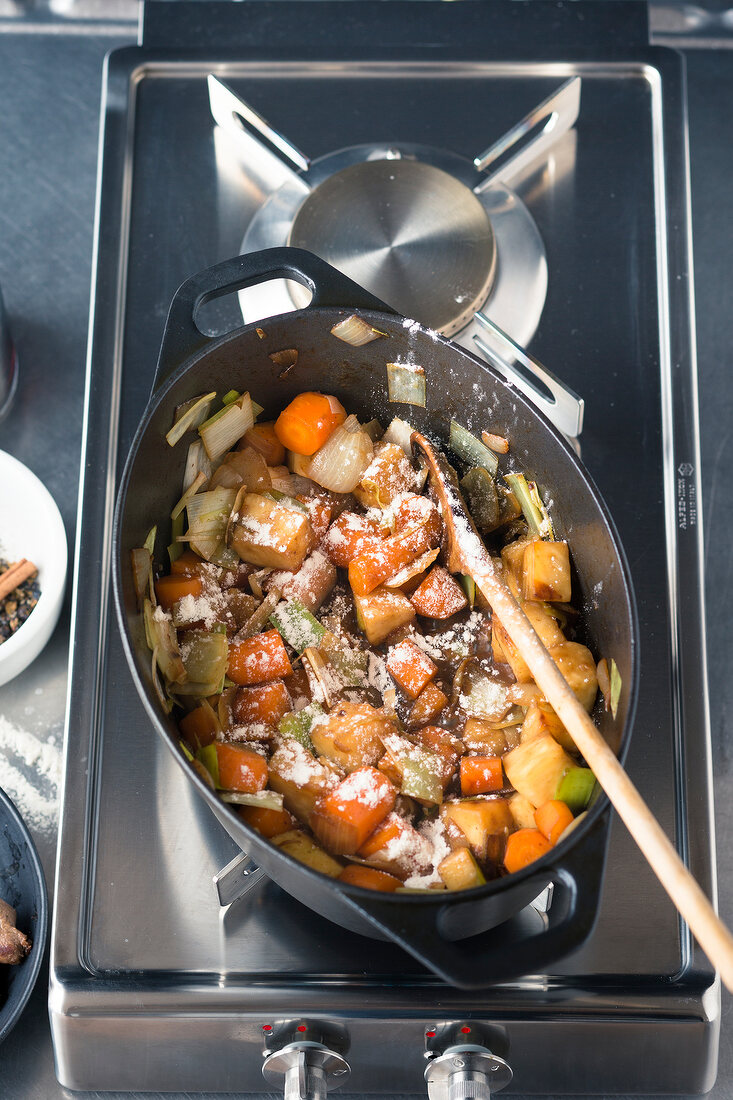 Venison ragout being made: vegetables being fried in a roasting tin