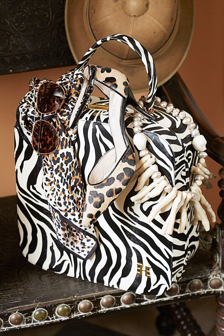 A large animal-print handbag, sandals and accessories