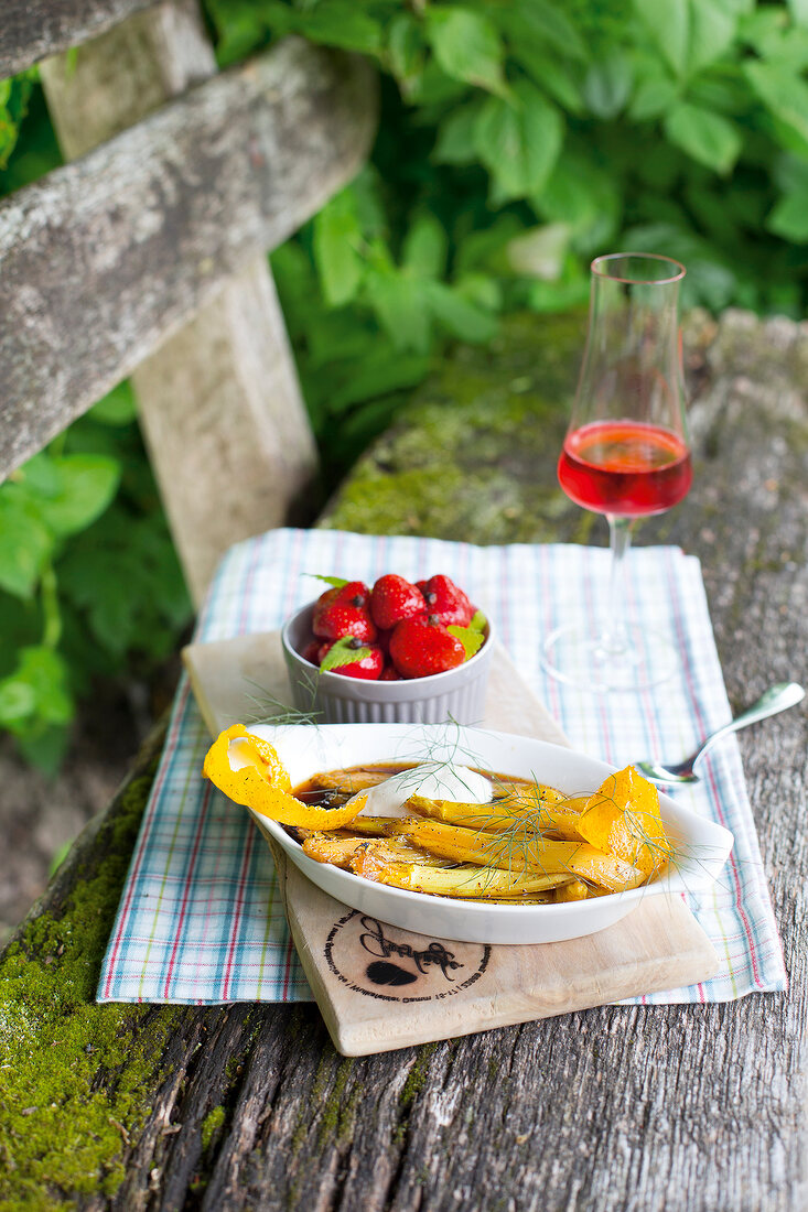 Vanilla asparagus and marinated strawberries on a bench outside