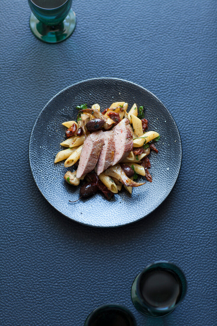 Veal fillet on a bed of penne with artichokes and olives