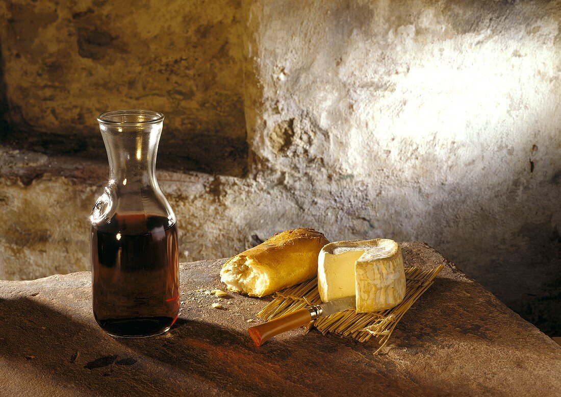 Camembert with piece of baguette and red wine