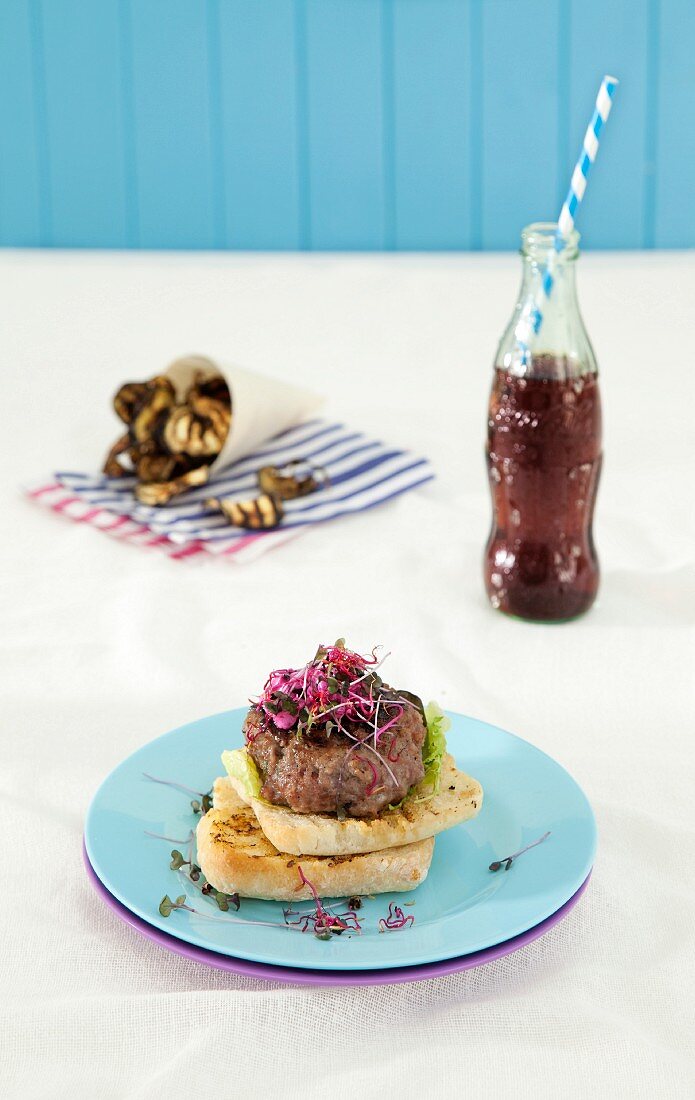 Lamb burger with mint sauce and beetroot tzatziki, served with aubergine chips and a soft drink