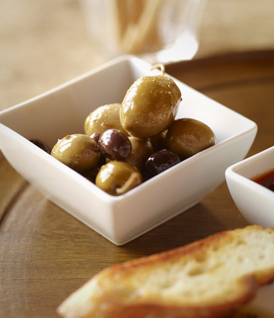 Assorted Green and Black Olives in a Dish with Crostini