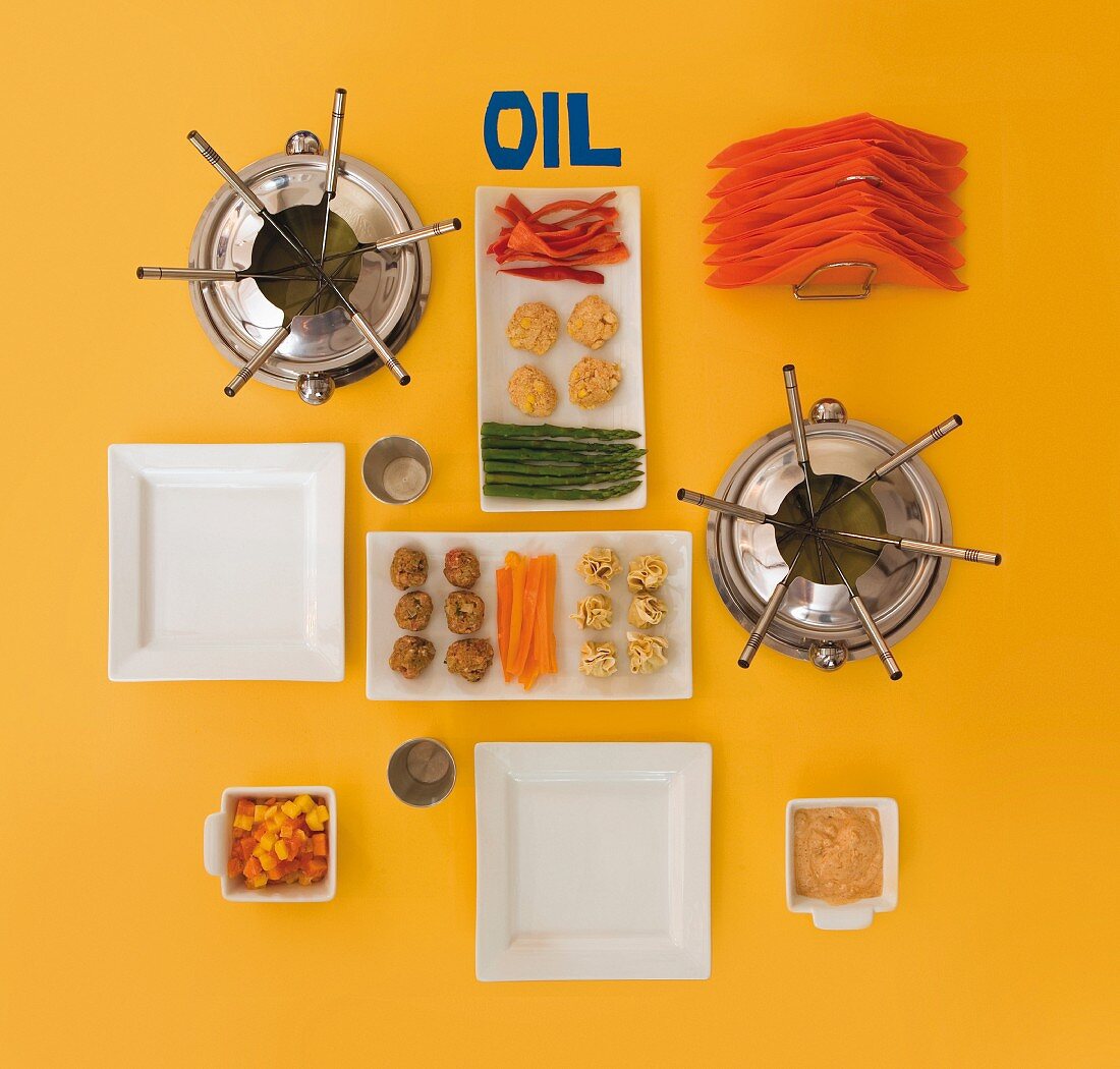 Utensils and ingredients for a fondue with oil (view from above)