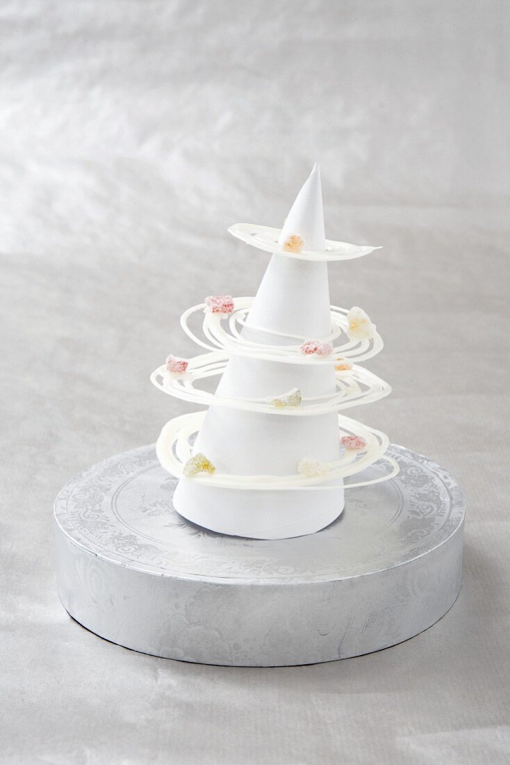 A white Christmas tree made from paper, with a chocolate garland
